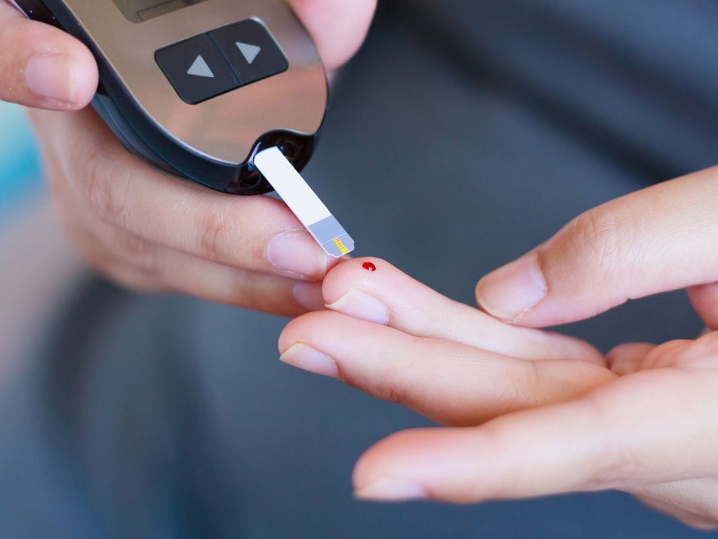 pessoa verificando a glicemia em aparelho
