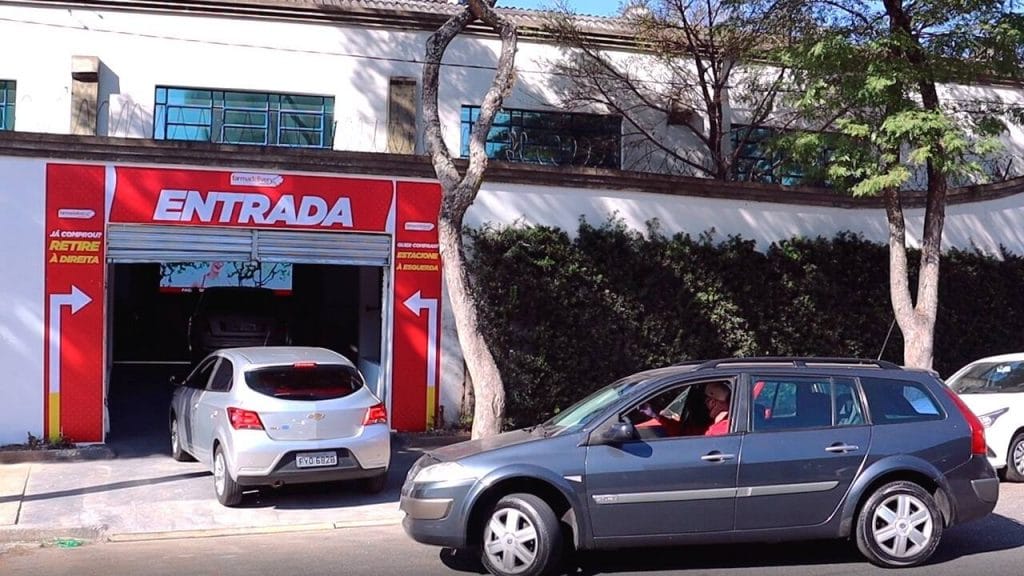 Dois carros em frente a entrada do Drive-in Farmadelivery.