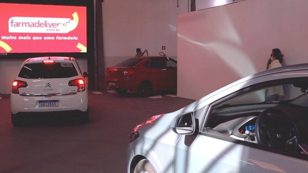 Fila de carros dentro do Drive-in Farmadelivery aguardando atendimento.