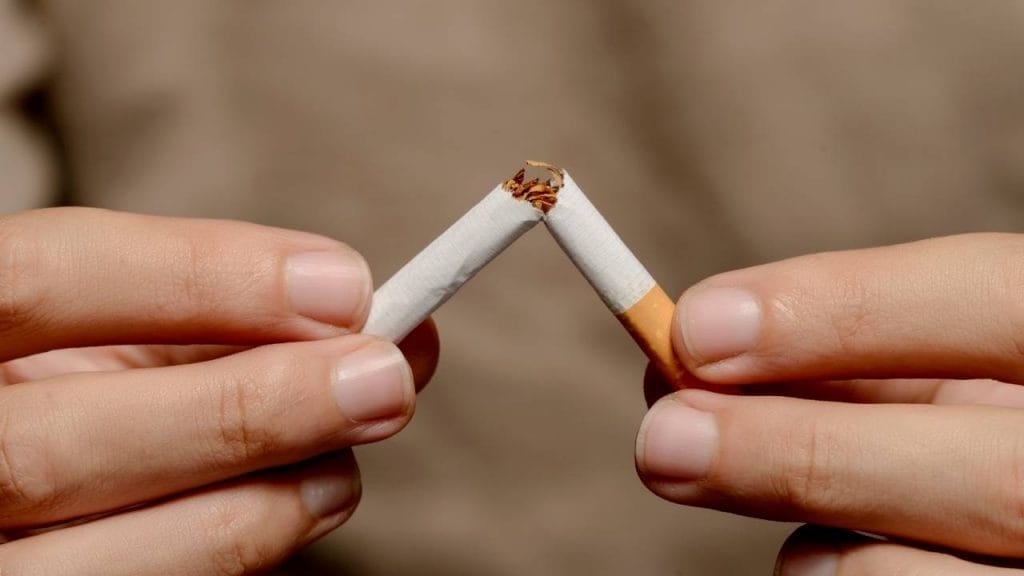 Pessoa partindo um cigarro ao meio.