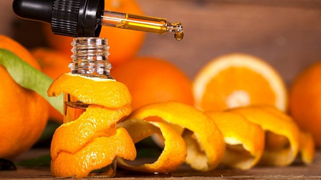 Demonstração do frasco de óleo de laranja como hidratante caseiro para pele seca.