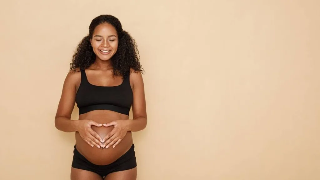 Mulher grávida com a pele da barriga bem cuidada e sem estrias.