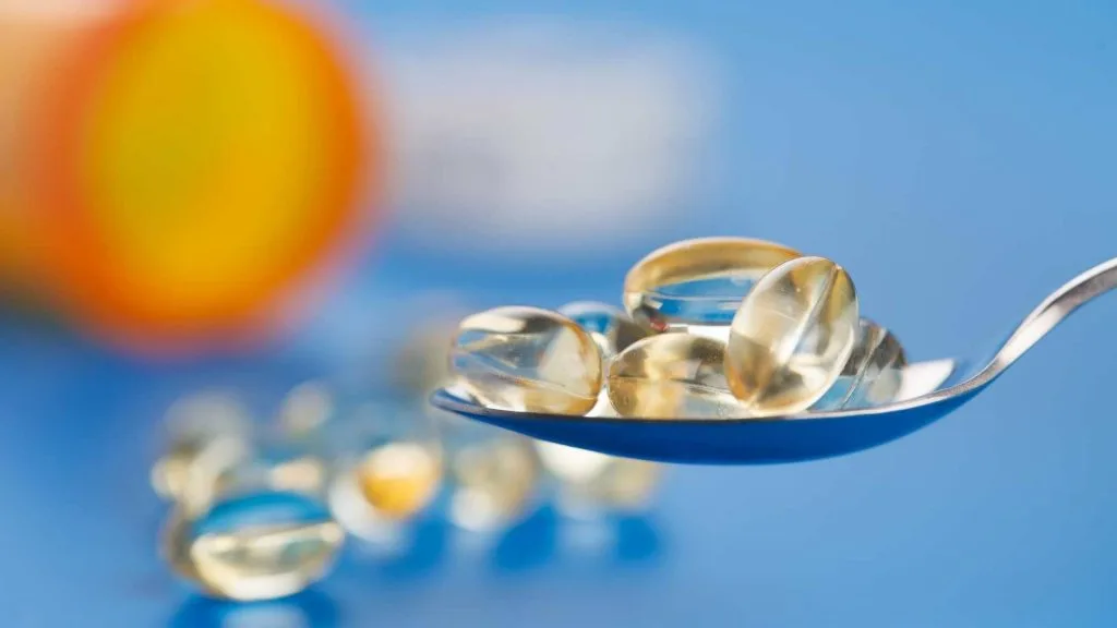 colher com cápsulas de vitamina
