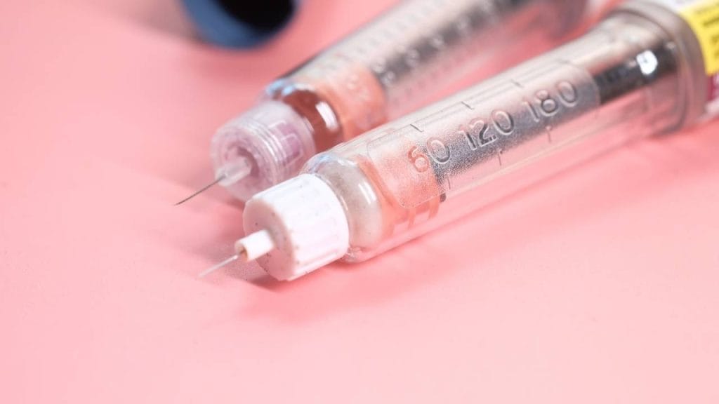 Duas seringas de insulina em cima de uma mesa.