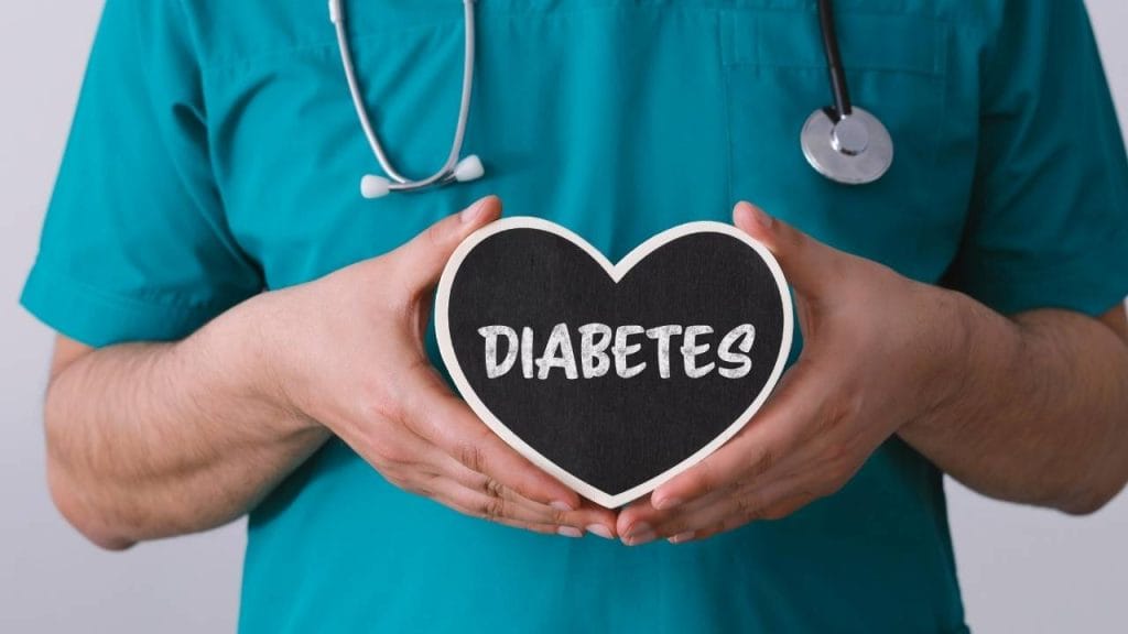Profissional da saúde segurando uma placa em formato de coração escrito "diabetes".