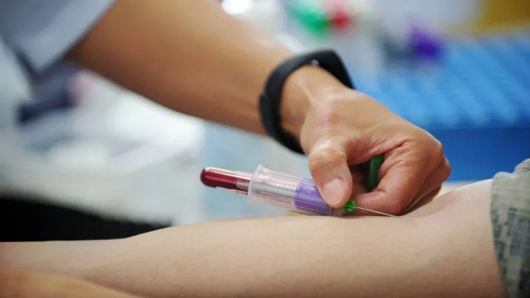 Profissional coletando sangue para realizar exame para imunidade.