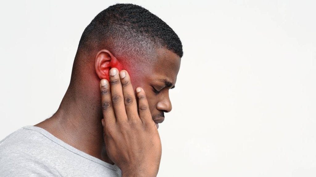 Homem com dor de ouvido, causada pela otite.