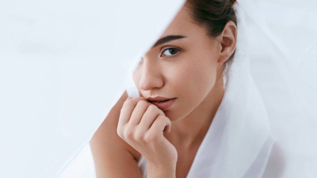 Mulher atrás de lenços brancos.