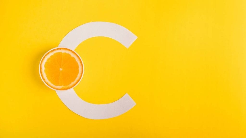 Imagem ilustrativa da letra C com meia laranja, representando a vitamina c para imunidade.