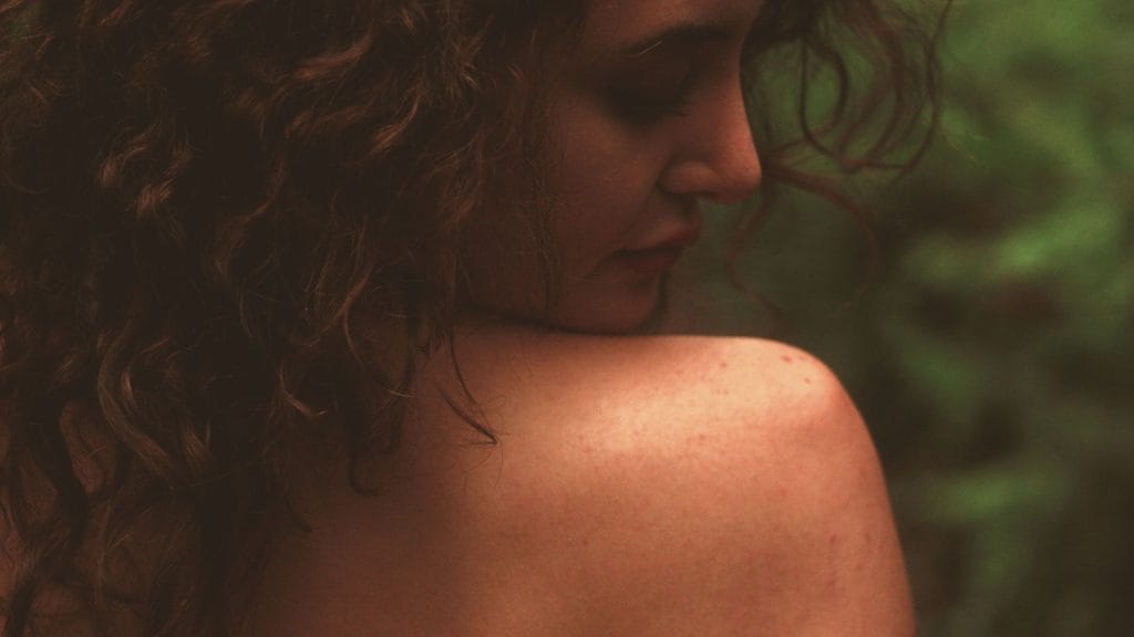 Mulher de costas, mostrando a pele do oombro.