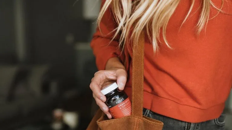 mulher com vitamina na bolsa