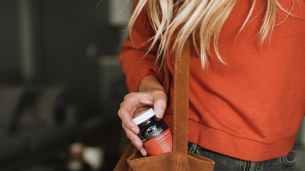mulher com vitamina na bolsa