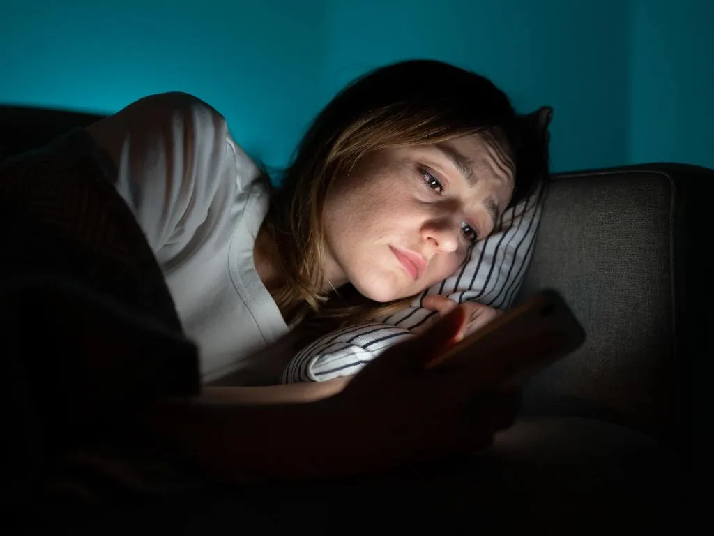 Mulher no celular antes de dormir