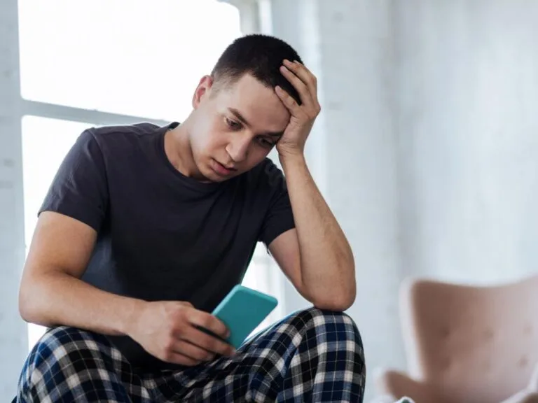 Homem estressado segurando celular