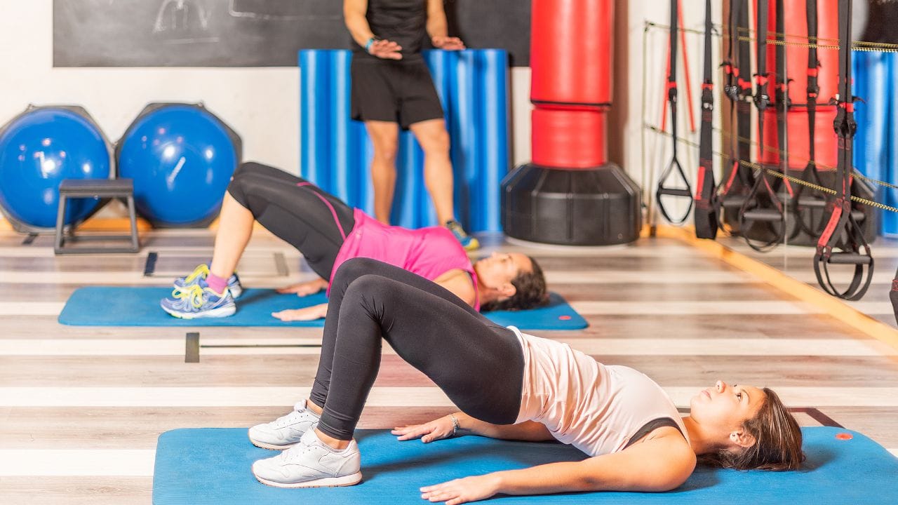 duas mulheres fazendo elevação pélvica no chão
