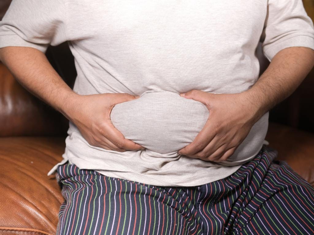homem segurando a barriga mostrando gordura