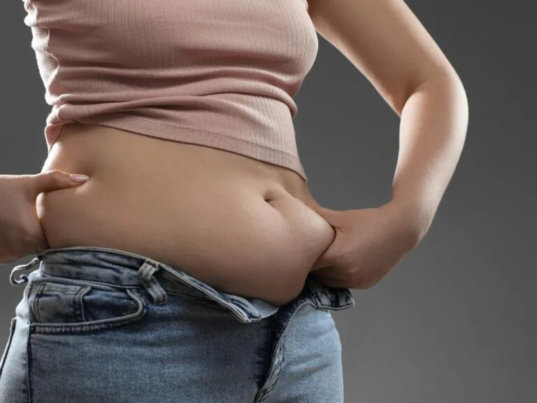 Mulher segurando gordura da barriga