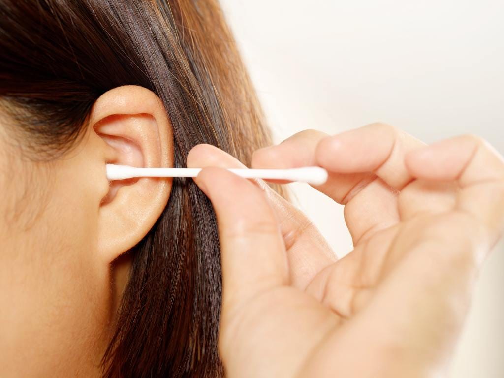 Pessoa tirando cera do ouvido